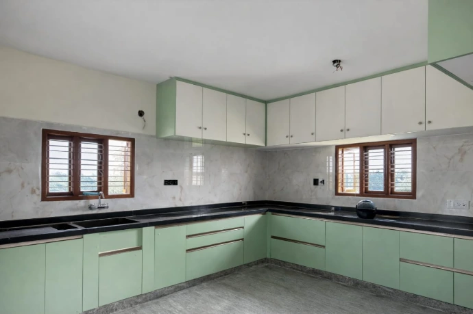 Spacious modern modular kitchen with white overhead cabinets and natural lighting