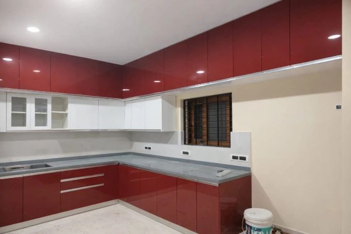 L-shaped modular kitchen design featuring premium maroon and white cabinets